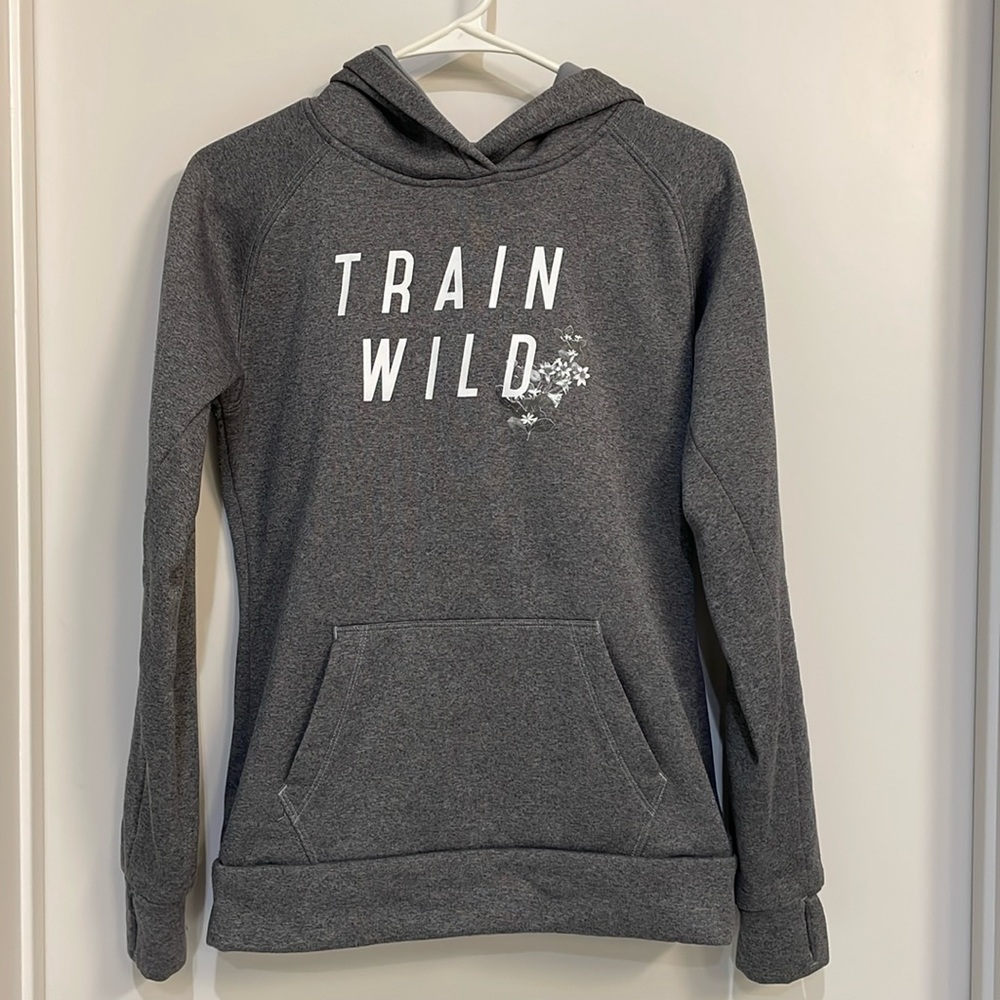 Gray hoodie with pocket in front and center. Has thumb holes.